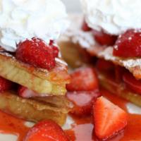 Strawberry French Toast · Golden, thick sliced French toast, topped with fresh strawberries and strawberry syrup. Dust...