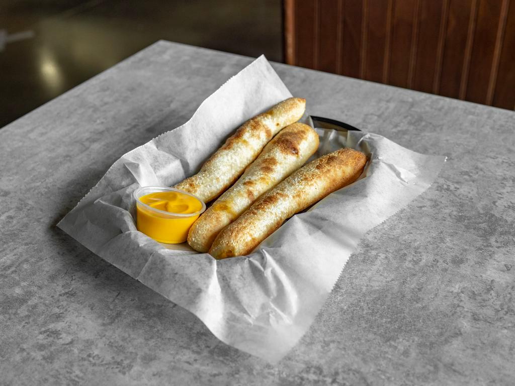 Pepperoni Sticks · Three fresh-baked breadsticks stuffed with pepperoni and cheese served with a choice of red sauce, cheddar cheese, nacho cheese, or garlic butter.