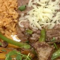 Steak Fajitas House Specialty · Marinated, tender strips of steak sauteed with fresh vegetables. Served with rice, beans, an...