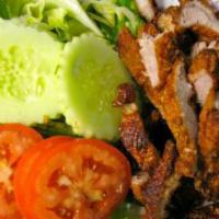 65. Deep Fried Pork · Deep-fried pork topped with fried garlic. Served with larb sauce, cucumbers and green leaf l...
