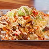 Macho Nachos · Crisp corn tortilla chips topped with white queso, cheddar and Chihuahua cheeses, olives, sa...