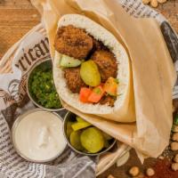 Falafel pita · Hummus, tahini, falafel, Israeli salad and pickels. Vegan.