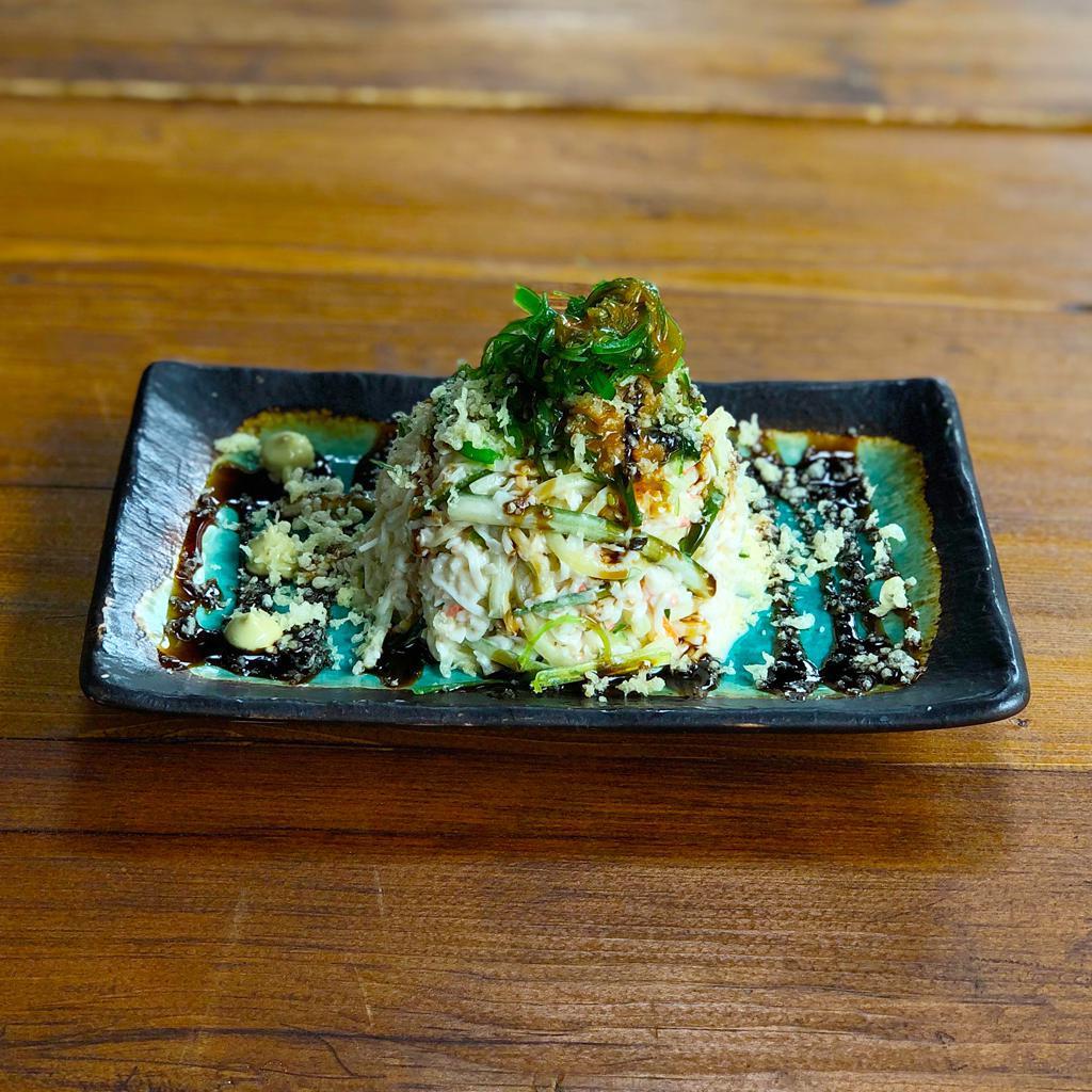 Kani Salad · Crabstick and cucumber mixed with Japanese mayo and spicy miso dressing. Topped with wakame seaweed, tempura flakes and wasabi drizzle. Contains fish.