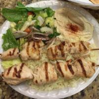 Mini Chicken Kabob · Tender chicken breast cubes grilled and served with rice, salad, hummus, and a pita.