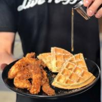 Chickawaffadopolis · Fried chicken tenders over a buttermilk waffle with syrup and powdered sugar.