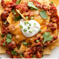 Nachos · Crispy tortilla chips topped with veggie chili,  melted cheddar, pico de gallo, chopped lett...