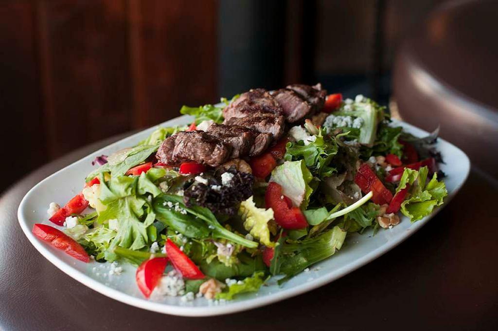 Shamrock Steak Salad · Mixed greens tossed in balsamic dressing: topped with grilled sliced steak prepared medium, blue cheese crumbles, walnuts, and red peppers.