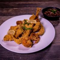 Combination Basket · 4 hand-battered catfish pieces and 2 jumbo shrimp served over a bed of fries and hushpuppies.