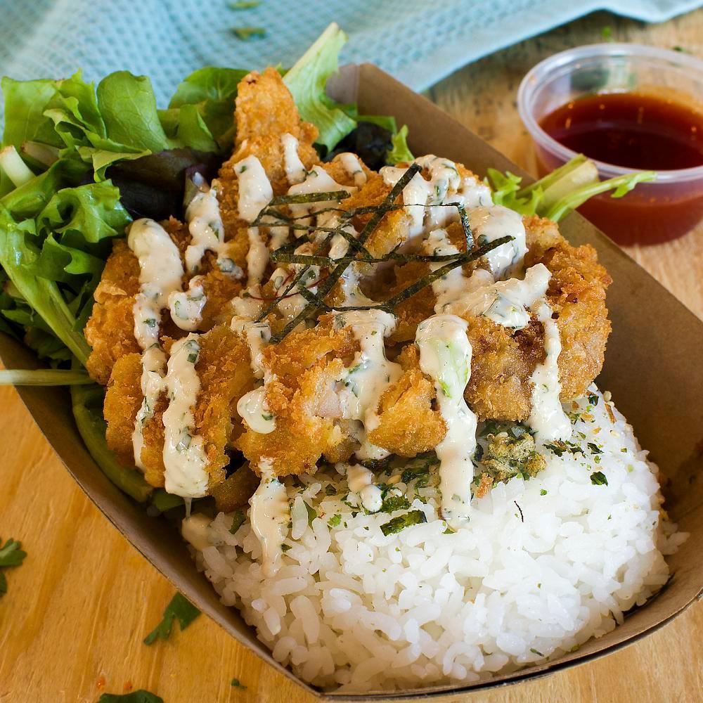 Crispy Chicken Bowl **NEW ITEM** · *NEW ITEM* All natural brined panko chicken served on a furikake white rice and soy ginger dressed spring mix, yellow daikon pickles, ponzu garlic spread, kimchi, and nori. Side of honey sriracha sauce.