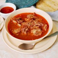 Birria en consome · Goat meat in a consome served with onions, cilantro, salsa, limes and tortillas.