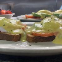 Avocado Toast Benedict · Multi Grain Toast, Topped with Sliced Tomato, sliced Avocado, Poached Eggs and Hollandaise