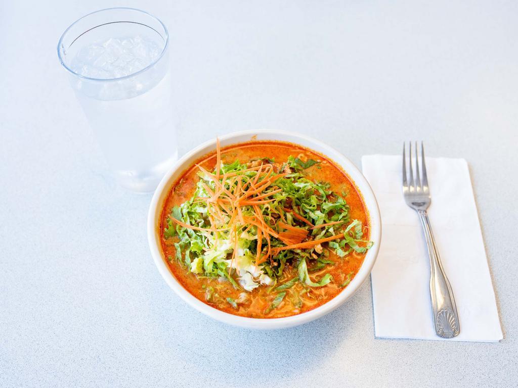 32. Kapoon Soup · Coconut curry noodle soup. Chicken breast and galanga root in red curry, coconut milk, beans sprouts, carrots and lettuce/cabbage served over rice noodles. A little Spicy.  
(Please specify if you would like cabbage or lettuce)