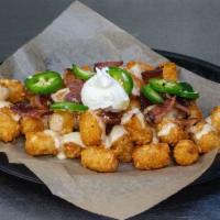 Rapture Tots · Tater Tots Topped w/ IPA Cheddar Sauce, Bacon, Jalapenos & Sour Cream.