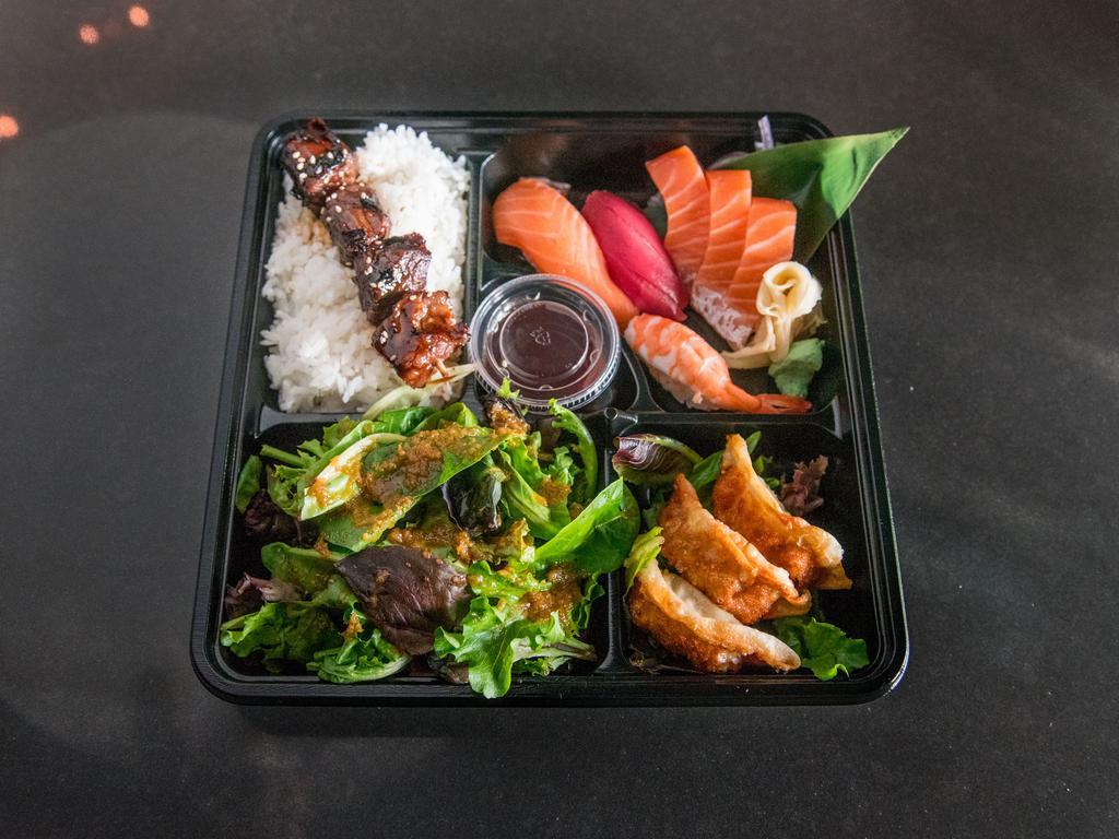 B1. Bento Box · Rice, salad, 3 pieces gyoza, beef yakitori, 3 pieces salmon sashimi, 1 piece tuna, 1 piece salmon and 1 piece shrimp nigiri.
