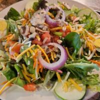 Mom's Garden Salad · Mix of fresh greens topped with tomatoes, sliced cucumber, red onion, carrots, shredded chee...