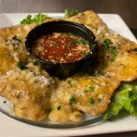 Toasted Ravioli · Cheese filled fried ravioli tossed in our house-made garlic parmesan sauce and served with a...