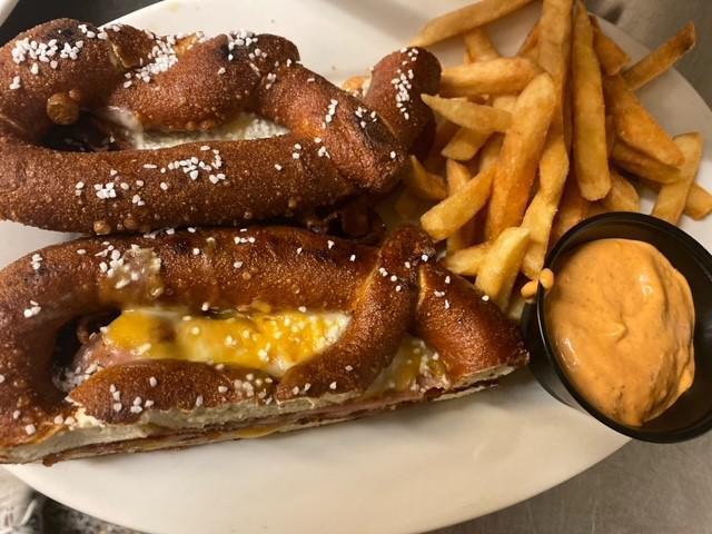 Ultimate Pretzel Melt Sandwich · Two salted pretzels jam-packed with bacon, ham, cheddar, 
and provolone cheese. Pressed and seared on our
seasoned flat top and served with a side of house-made 
beer cheese.