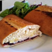 Turkey Sandwich · Turkey, Melted Brie and Cranberry Sauce on Whole Wheat artisan roll. Served with organic mix...
