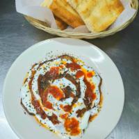 Burani Badunjan · Savory vegetarian dish consisting of fried eggplants topped with tomato sauce and yogurt. Se...