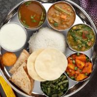 South Indian Thalis · Rice, your choice of one chappathi or poori, sambar, rasam, kurma, kootu, poriyal, special k...
