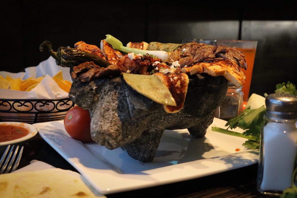 Chante Molcaxitl · Grilled chicken, steak, chorizo, shrimp, jalapeno pepper, nopal (Mexican cactus), cheese served in a roasted salsa, in a hot lava rock with black refried beans, rice and pico de gallo choice of three corn or flour tortillas.