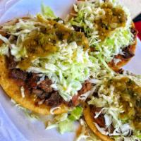 Al Pastor Sope · Spicy marinated pork with pineapple on a Soft open faced fresh tortilla topped with beans, c...