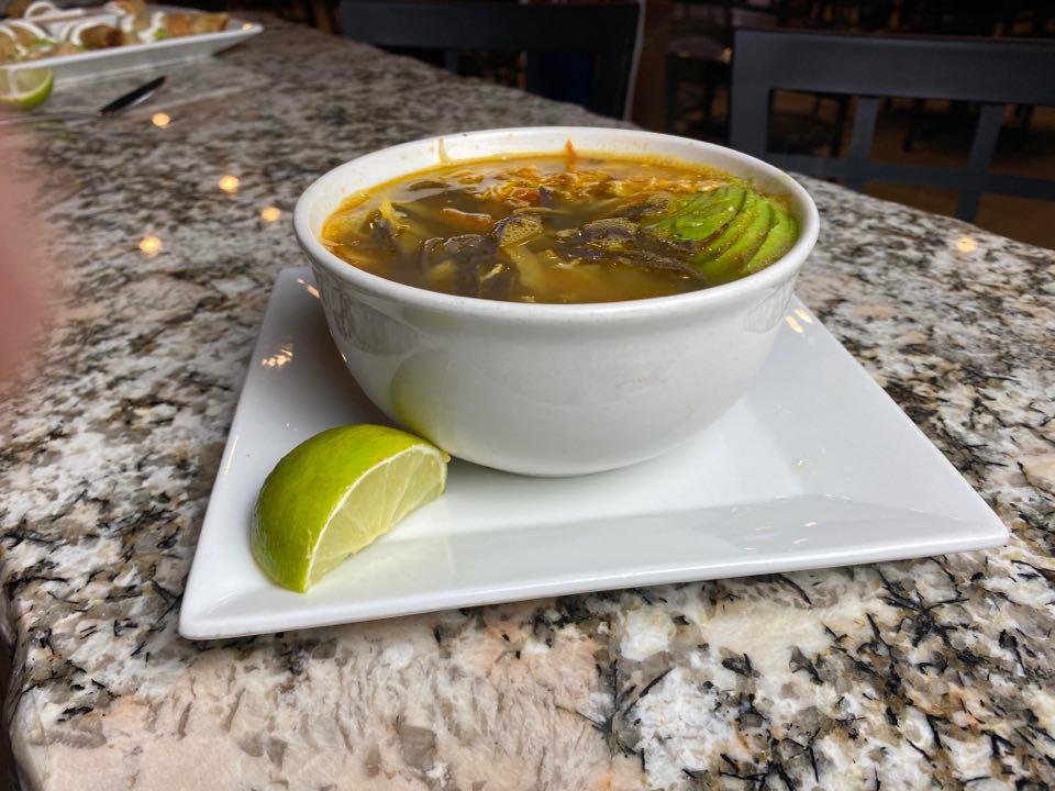 Tortilla Soup · Homemade chicken broth with shredded chicken. Topped with shredded cheese, tortilla strips, and avocado slices.
