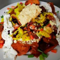 Mediterranean Nacho Platter · Crispy pita chips topped with feta cheese crumbles, diced tomatoes, pepperoncini peppers, Ka...