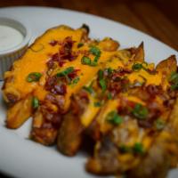 Loaded Potato Wedges · Quartered potatoes topped with cheddar cheese, chopped bacon and scallions. Served with ranc...