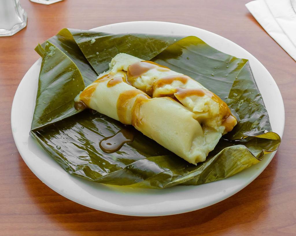Costa Rican Tamal · Pork, yellow rice, green beans, and carrots wrapped in a banana leaf.