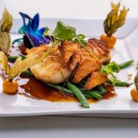 Chilean XO Sea Bass · Grilled Chilean sea bass and fish cake with Asian XO seafood dressing.