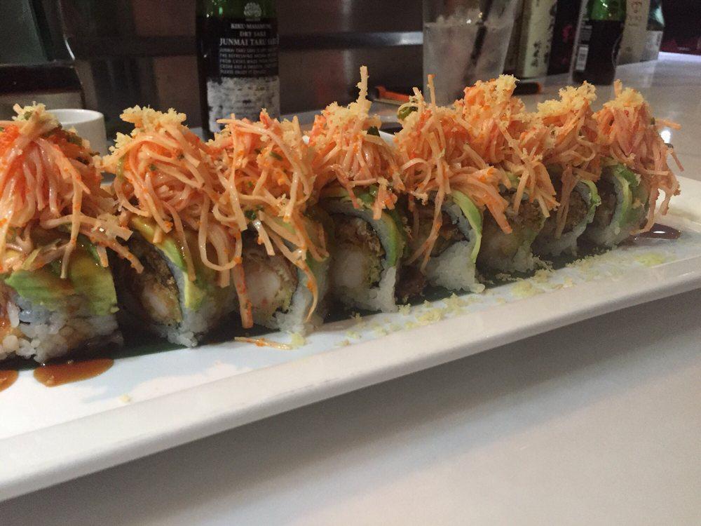 Dancing Crab Roll · prawn tempura inside with cucumber, topped with a sheet of avocado, and spicy imitation crab with crunch and eel sauce