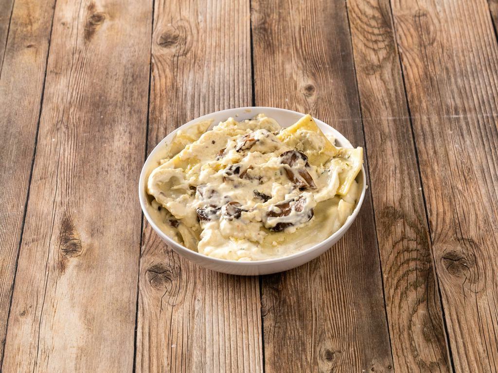 Porcini Wild Mushroom Ravioli · Porcini ravioli topped with a delicious mushroom alfredo cream sauce and roasted mushrooms.
