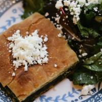 Spanakopita · Spinach pie topped with salad.
