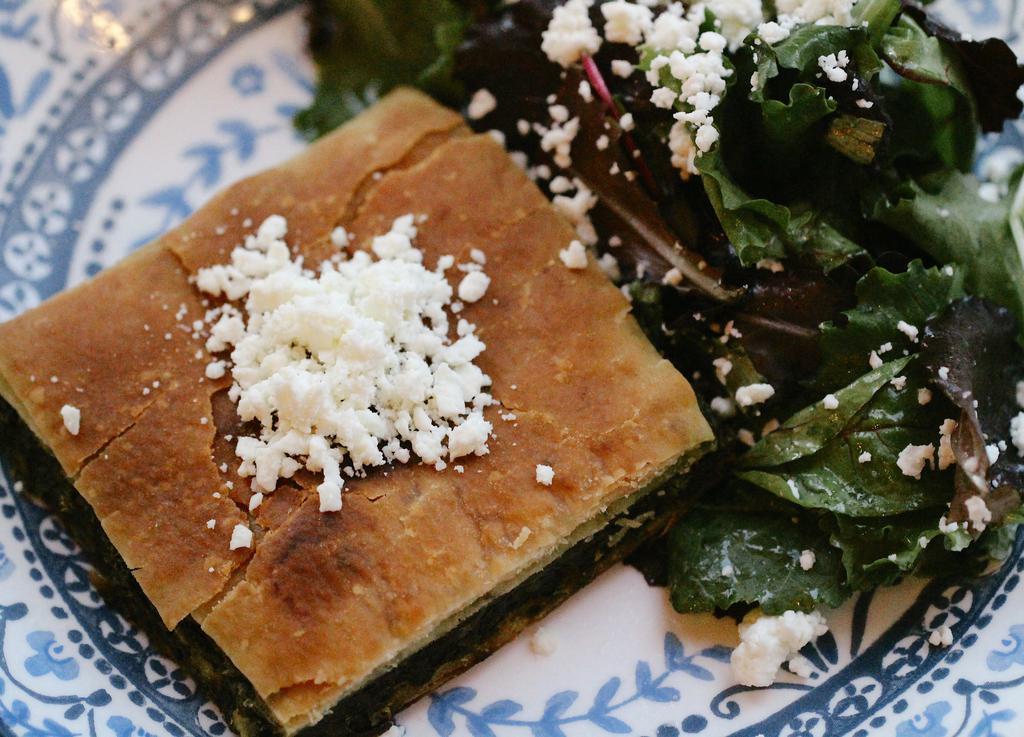 Spanakopita · Spinach pie topped with salad.