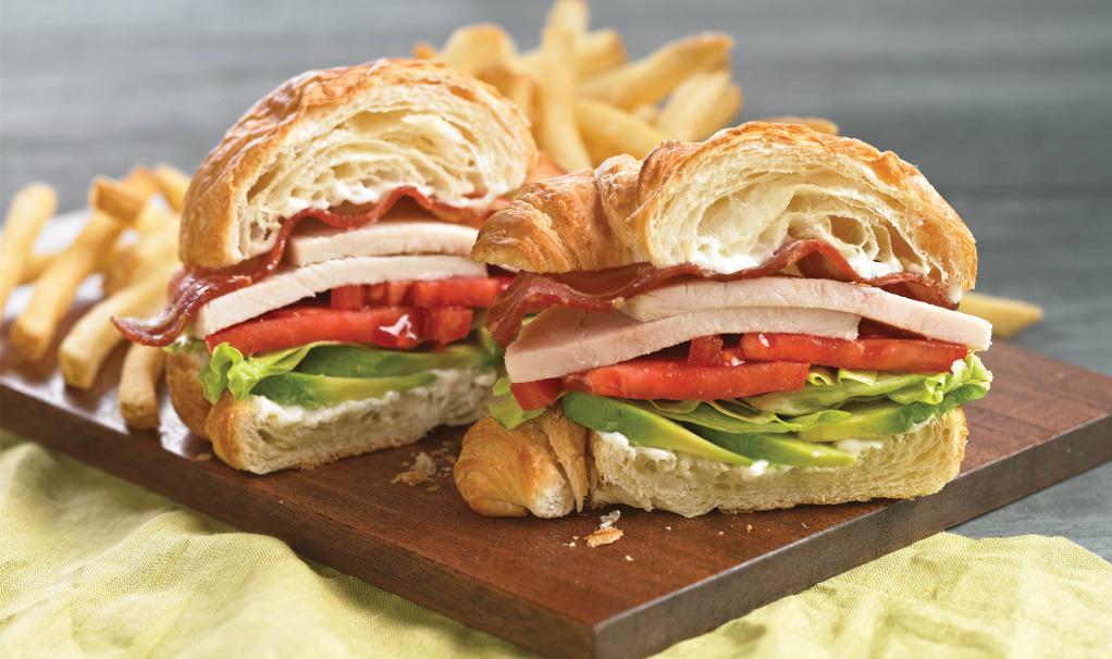Turkey Croissant Club Sandwich · Roasted turkey, applewood smoked bacon, tomato, avocado, lettuce and mayonnaise on a flaky butter croissant. Served with your choice of side.