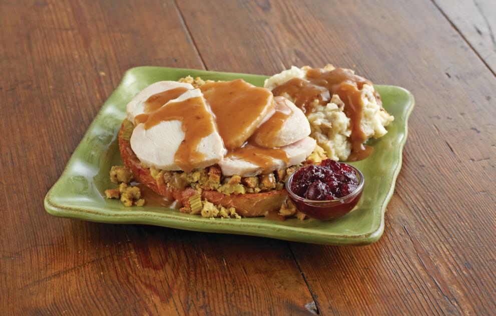 Hot Open-Faced Turkey Sandwich · Roasted turkey, apple-sage stuffing and house-made giblet gravy over grilled sourdough bread. Served with fresh mashed potatoes and cranberry sauce. No additional side included.