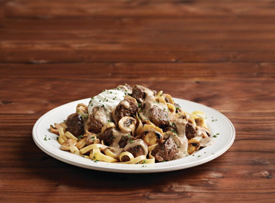 Home-Style Beef Stroganoff · Tender beef sautéed with fresh mushrooms in a demi-glace red wine beef sauce, with caramelized onions and a hint of Grey Poupon® Dijon. Served over fettuccine noodles with a dollop of sour cream.