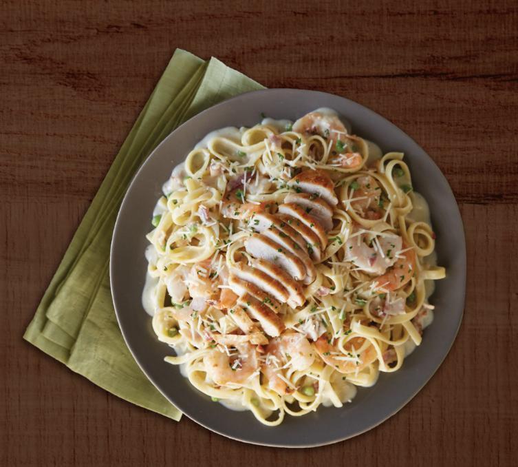 Shrimp & Chicken Carbonara · Grilled chicken breast and tender shrimp lightly sautéed in a rich, creamy sauce blended with crispy bacon, fresh garlic, egg yolk, green peas and parmesan cheese, then topped with fresh parsley.