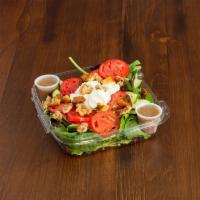 Warm Goat Cheese and Carmelized Walnut Salad · Baby spinach, tomatoes and cucumber topped with warm goat cheese, caramelized walnuts an fre...