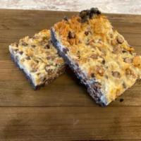 Magic Bar · Chocolate cookie bottom topped with walnuts, coconut and chocolate chips in sweet vanilla ba...