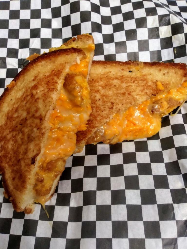 The Mac & Cheesy · Mac and cheese bites, cheddar Jack cheese, smooth cheddar sauce , the creamiest, cheesiest, mac and cheese grilled cheese !  served with french fries or house made chips 