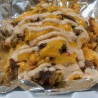 Cajun Steak Fries · French fries topped with grilled steak, peppers, caramelized onions, cheddar cheese sauce an...