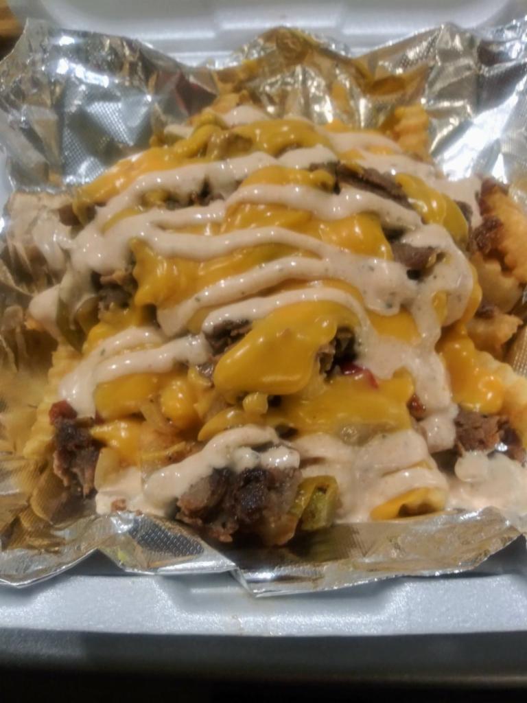 Cajun Steak Fries · French fries topped with grilled steak, peppers, caramelized onions, cheddar cheese sauce and cajun ranch 
