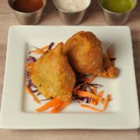 VEGETABLE SAMOSAS · 2 PIECES.  Triangular puffed pastry stuffed with cubed potatoes, green peas, carrots,  and m...