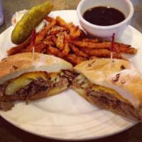French Dip Sandwich · Philly Steak, Cheddar cheese and sauteed onions on a kaiser roll. Served with Aus jus for di...