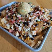 Nachos · Fried white-corn tortilla chips topped with a veggie black bean mix, white cheese blend, our...