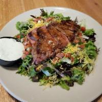 Spicy Steak Salad · A spicy 8 oz. sirloin served atop organic spring and romaine mix with shredded cheddar, pico...