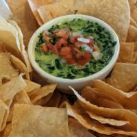 Spinach Artichoke Dip · Creamy spinach and artichoke dip served with homemade tortilla chips