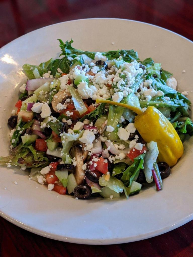 Greek Salad · Fresh mixed greens, black olives, cucumbers, onion and diced tomatoes served with a Greek vinaigrette topped with feta cheese